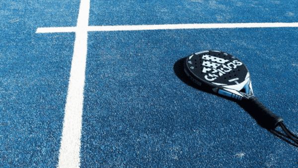 Padel racket on blue artificial grass