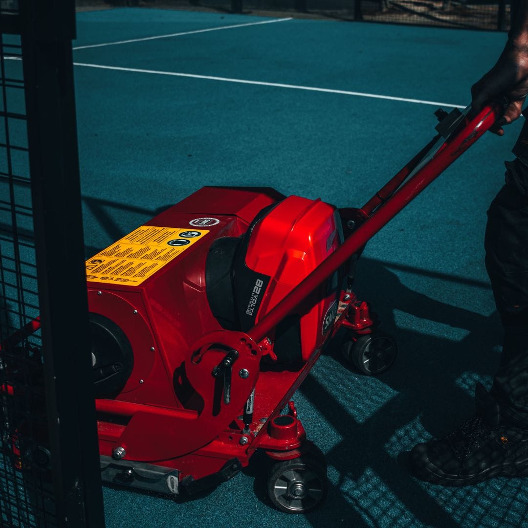 Onderhoudsman gebruikt de SMG voor onderhoud aan het kunstgras